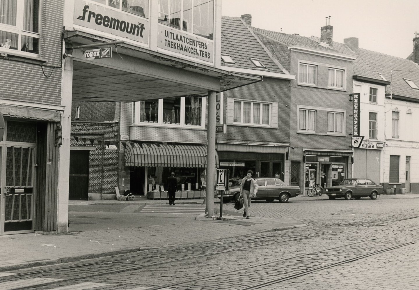 Straatbeeld met woningen, winkels en uitlaatcenter Freemount in Gent