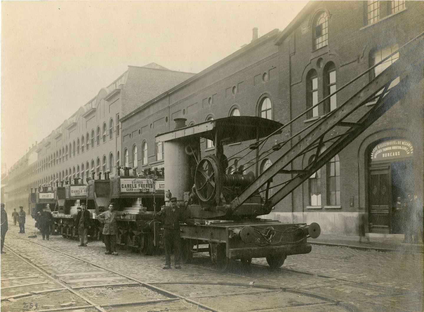 Onderdelen van industriële dieselmotor op wagons voor de fabrieksgebouwen van machinebouwer Carels in Gent