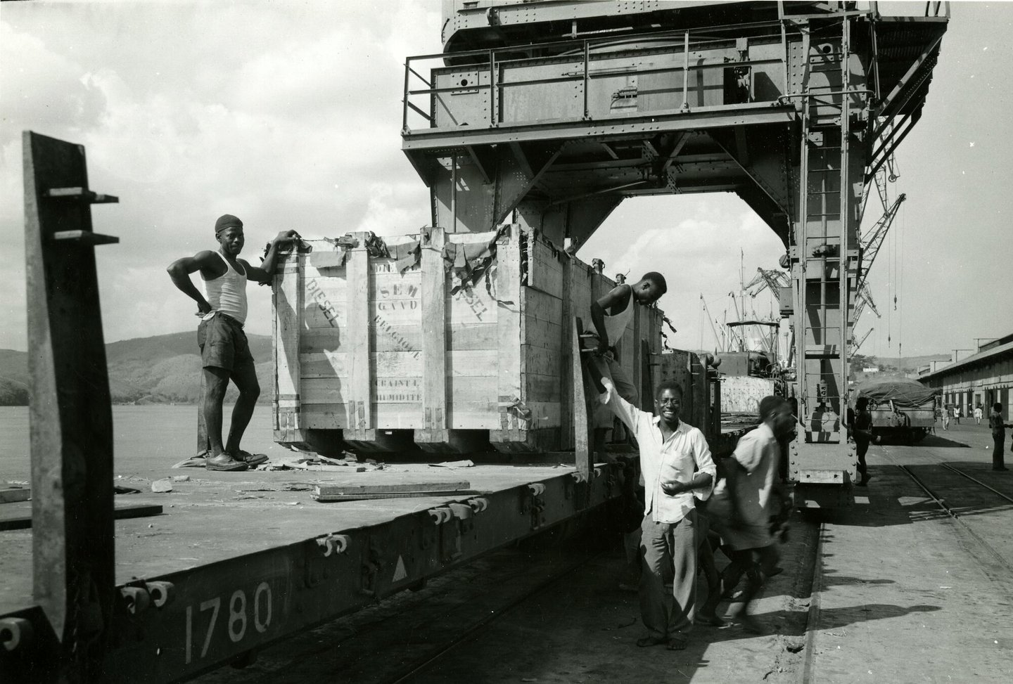 Lossen van ingekiste onderdelen van dieselmotor geproduceerd door SEM-Carels in Gent in de haven van Matadi (Congo)