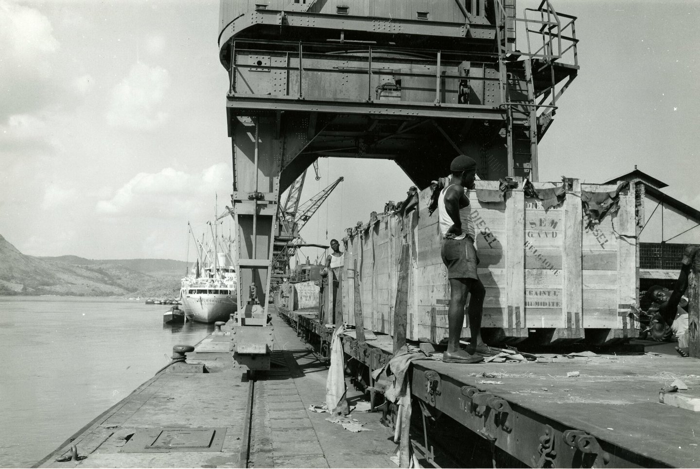 Lossen van ingekiste onderdelen van dieselmotor geproduceerd door SEM-Carels in Gent in de haven van Matadi (Congo)